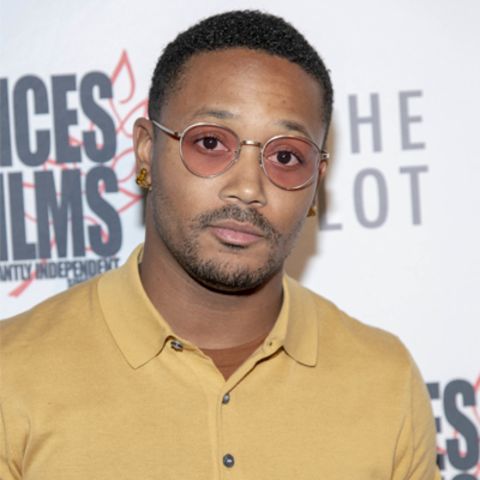 Romeo Miller in a brown t-shirt poses a picture.